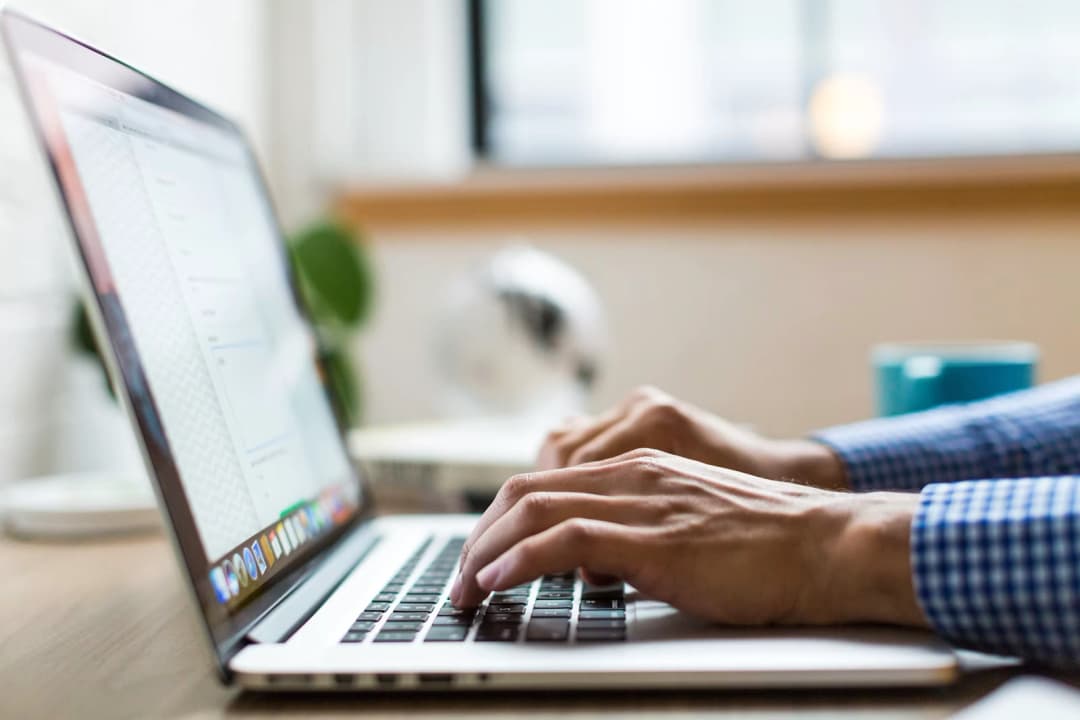 Close up of hands using a laptop keyboard, highlighting digital interaction