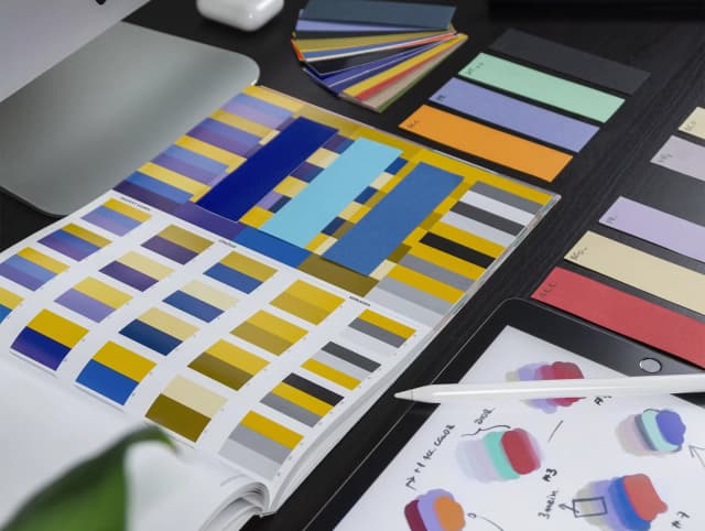 A desk set up for a designer working on color contrasts and accessibility on a website project.