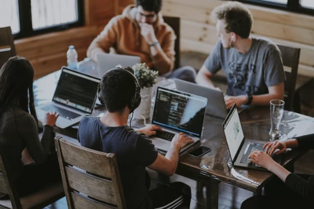 A group of people working together on their laptops to make a website ADA compliant